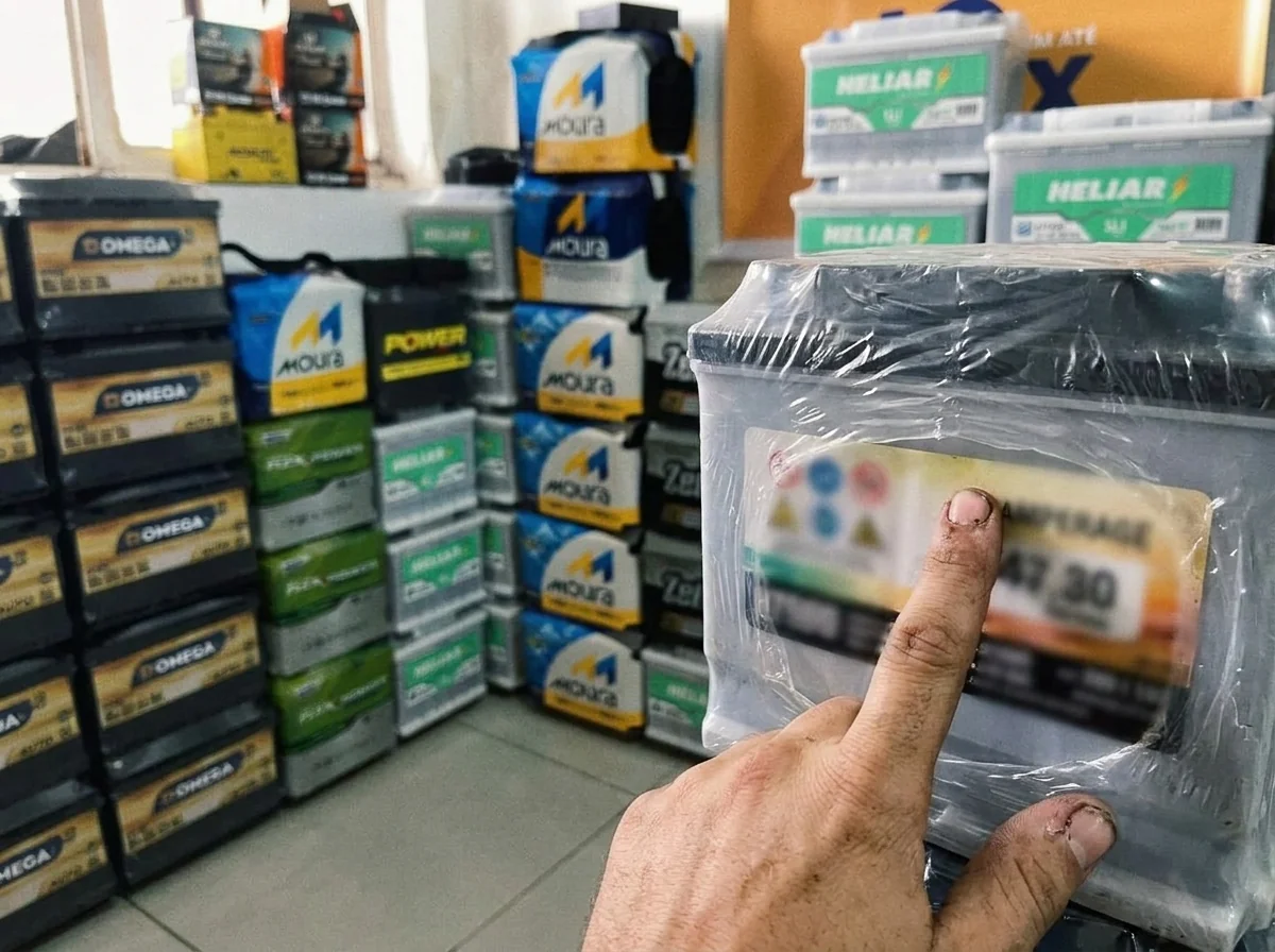 Técnico conferindo a etiqueta de amperagem de uma bateria de carro antes da instalação
